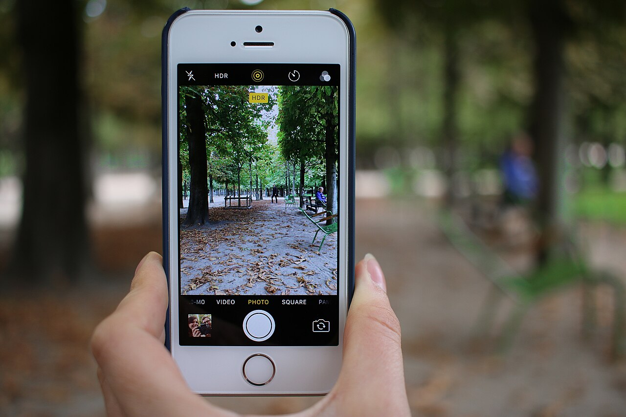 A person taking a photo with a smartphone outdoors